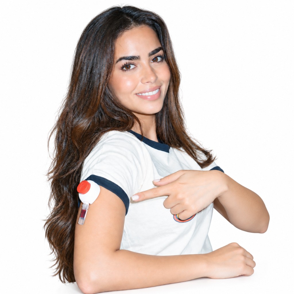 A woman smiling and pointing to the needle-free Gini blood collection device on her upper arm